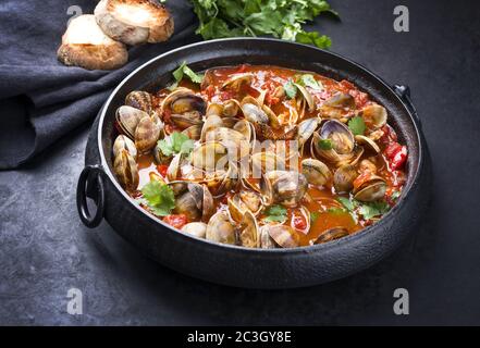 Tappezzeria giapponese cotta con paprika e baguette in salsa piccante all'aglio di pomodoro come spicchio in un moderno pentola di design Foto Stock