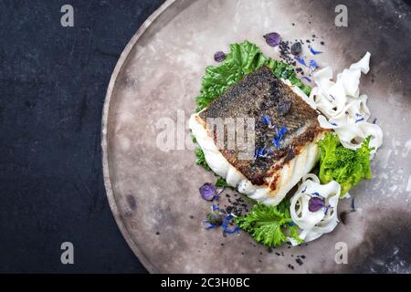 Filetto di merluzzo europeo fritto gourmet skrei con rapini broccoli e tagliatelle come vista dall'alto su un piatto di design moderno con copia Foto Stock
