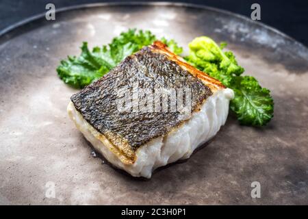 Filetto di merluzzo europeo fritto gourmet skrei con rapini broccoli come primo piano su una piastra di design moderno Foto Stock
