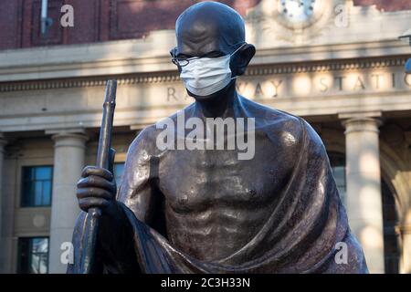 Statua di Gandhi che indossa una maschera medica durante il blocco Covid19 fuori dalla stazione ferroviaria di Wellington, Isola del Nord, Nuova Zelanda Foto Stock