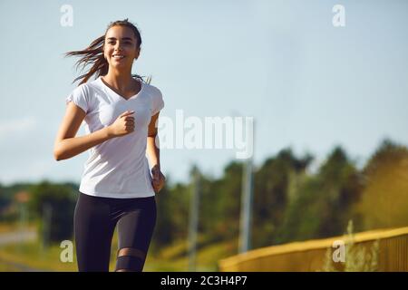 Ragazza corridore corre lungo la strada Foto Stock