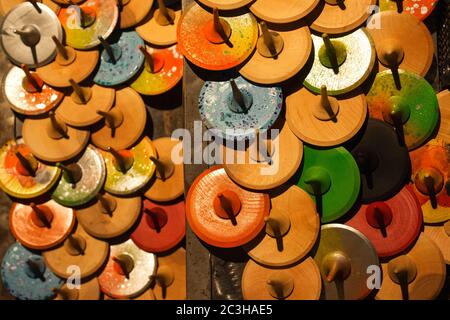 Vista dall'alto su colorati giocattoli in legno dipinti a mano - cime dei pioli o capricci, come sfondo creativo con bokeh dorato chiaro sfocato Foto Stock