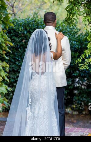 Prima riunione degli sposi novelli lo sposo gira intorno quando la sposa si avvicina a lei Foto Stock