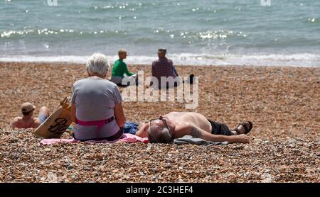 Brighton UK 20 giugno 2020 - i bagnanti godono oggi del caldo sole sulla spiaggia e sul lungomare di Brighton, mentre le restrizioni di blocco sono gradualmente alleviati in Inghilterra durante la crisi pandemica del coronavirus COVID-19 . : Credit Simon Dack / Alamy Live News Foto Stock