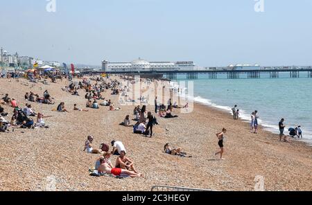 Brighton UK 20 giugno 2020 - i visitatori godono oggi del caldo clima soleggiato sulla spiaggia e sul lungomare di Brighton, mentre le restrizioni di blocco sono gradualmente attenuate in Inghilterra durante la crisi pandemica del coronavirus COVID-19 . : Credit Simon Dack / Alamy Live News Foto Stock