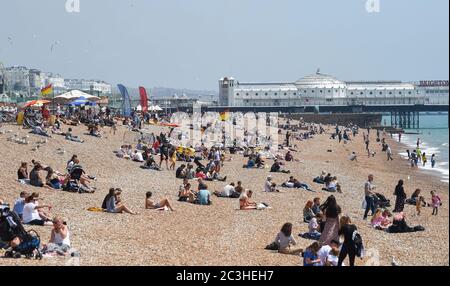 Brighton UK 20 giugno 2020 - i visitatori godono oggi del caldo clima soleggiato sulla spiaggia e sul lungomare di Brighton, mentre le restrizioni di blocco sono gradualmente attenuate in Inghilterra durante la crisi pandemica del coronavirus COVID-19 . : Credit Simon Dack / Alamy Live News Foto Stock