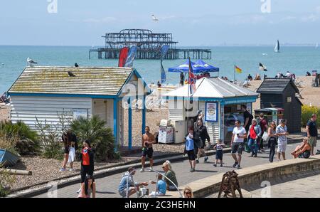 Brighton UK 20 giugno 2020 - i visitatori godono oggi del caldo clima soleggiato sulla spiaggia e sul lungomare di Brighton, mentre le restrizioni di blocco sono gradualmente attenuate in Inghilterra durante la crisi pandemica del coronavirus COVID-19 . : Credit Simon Dack / Alamy Live News Foto Stock