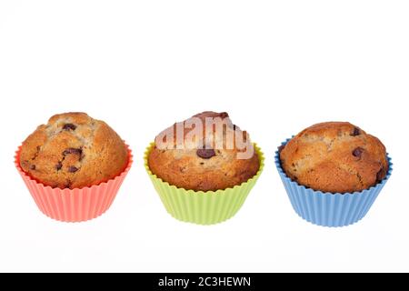 Tre muffin al cioccolato con chip alla banana in coloratissime custodie in silicone. Spazio per il testo. Foto Stock