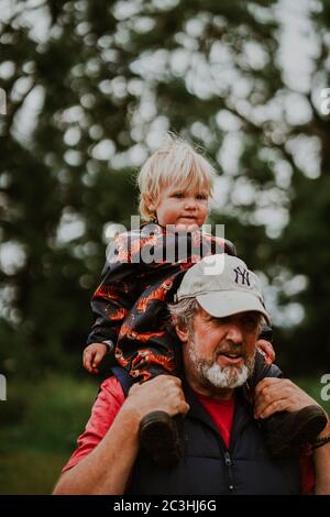 Nonno che porta il nipote sulle spalle Foto Stock