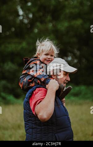 Nonno che porta il nipote sulle spalle Foto Stock