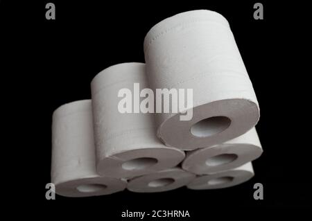 Rotoli di carta igienica impilati. Isolato su sfondo nero. Shot orizzontale. Primo piano. Vista dall'alto. Foto Stock