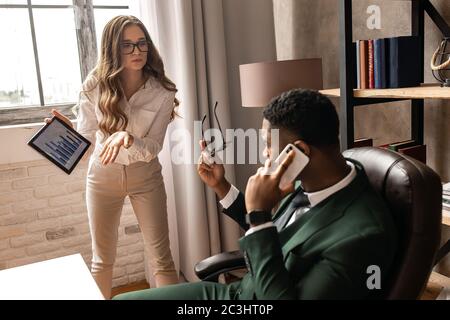 I partner che discutono sul posto di lavoro, non sono d'accordo con il documento, violazione di un accordo, condizioni inaccettabili. Foto Stock