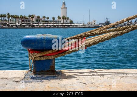 Linee di ormeggio. Corde fissate in un bullard blu su un molo vuoto con spazio per la copia Foto Stock