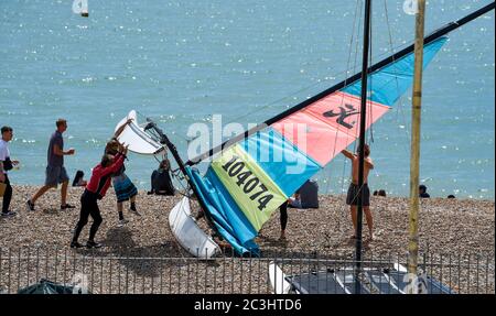 Brighton UK 20 giugno 2020 - i marinai impacchettano la loro barca via in una giornata calda di sole sulla spiaggia e sul lungomare di Brighton oggi come le restrizioni di blocco stanno gradualmente alleviando in Inghilterra durante la crisi pandemica di Coronavirus COVID-19 . : Credit Simon Dack / Alamy Live News Foto Stock