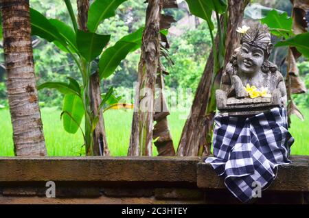 La scultura in pietra di bali Guardian con tessuto sarong in via Bali. Foto Stock