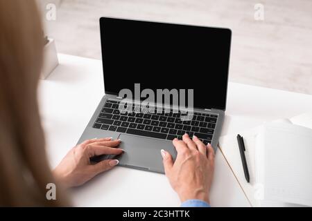 Marketing e smm. Donna lavora al laptop, vicino a notebook e penna Foto Stock