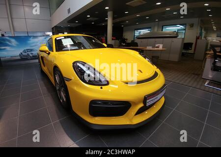 Russia, Mosca - 04 maggio 2019: Porsche Cayman GT4 gialla. Auto da corsa nello showroom del concessionario. Vista frontale Foto Stock