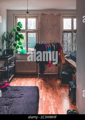 Immagine verticale di una camera da letto con i vestiti appesi sul panno supporto per appendiabiti Foto Stock