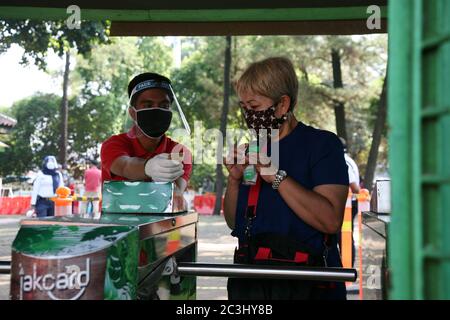 I visitatori che indossano maschere entreranno nell'ingresso al Ragunan Wildlife Park di Giacarta, Indonesia, sabato 20 giugno 2020. Il Ragunan Wildlife Park è stato riaperto per i visitatori nella terza settimana della fase di apertura della prima fase della transizione alle nuove restrizioni normali o sociali su larga scala (PSBB). Ma il Ragunan Wildlife Park limita il numero di visitatori a 1000 persone al giorno, con l'attuazione di rigorosi protocolli di salute. Come richiesto dalla registrazione online, i bambini sotto i 9 anni, le donne incinte e gli anziani sopra i 60 anni non sono autorizzati ad entrare, i visitatori sono anche tenuti a Foto Stock