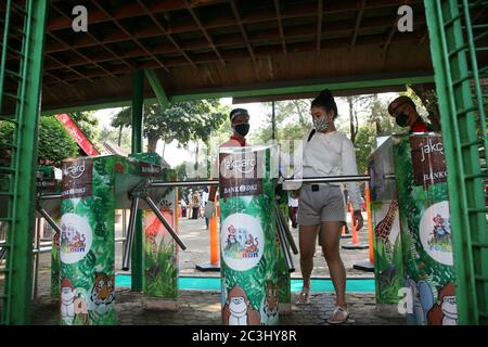 I visitatori che indossano maschere entreranno nell'ingresso al Ragunan Wildlife Park di Giacarta, Indonesia, sabato 20 giugno 2020. Nella terza settimana della fase di apertura della prima fase della nuova normale o transitoria delle restrizioni sociali su larga scala (PSBB), sono state riaperte numerose aree ricreative e giardini zoologici nella capitale Giacarta. Ma il Ragunan Wildlife Park limita il numero di visitatori a 1000 persone al giorno, con l'attuazione di rigorosi protocolli di salute. (Foto di Kuncoro Widyo Rumpoko/Pacific Press/Sipa USA) Foto Stock