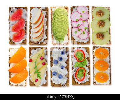 Panini con formaggio spalmabile e frutti di bosco freschi, frutta e verdura. Snack fresco e salutare con croccante su sfondo bianco. Foto Stock