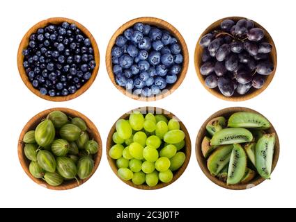 Cibo blu e verde isolato su sfondo bianco. Collage di frutta e bacche diverse. Mirtilli, mirtilli, uva, mirtilli d'oca, kiwi su Whi Foto Stock