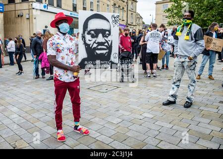 Chippenham, Wiltshire, Regno Unito. 20 Giugno 2020. Un uomo tiene un grande dipinto di George Floyd durante una protesta nera di BLM Lives Matter nel Market Place della città. Il raduno è stato organizzato per far sì che la popolazione locale attirasse l'attenzione sul razzismo nel Regno Unito e per mostrare solidarietà con altre proteste BLM che si sono svolte in tutto il mondo dopo la morte di George Floyd, morto nella custodia della polizia il 25 maggio a Minneapolis. Credit: Lynchpics/Alamy Live News Foto Stock