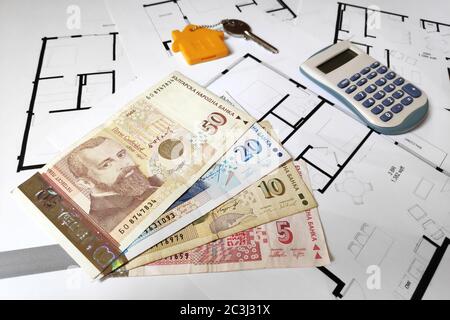 Primo piano su alcune banconote bulgaro lev, una chiave di casa e un calcolatore in cima alla pianificazione degli edifici. Foto Stock