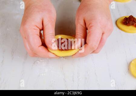 Donna che fa biscotti fatti in casa shortbread con marmellata di mirtilli. Foto Stock