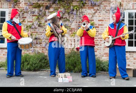 Downton, UK - 29 aprile 2017: Band folk vestita da gnomi da giardino che intrattengono la folla all'annuale Cukoo Fair di Downton, Wiltshire Foto Stock