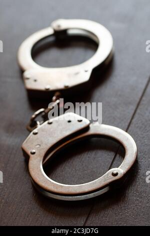 Ripresa verticale ad alto angolo di manette metalliche su un legno superficie Foto Stock