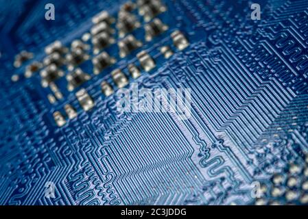 Macro foto dei percorsi elettrici sulla scheda a circuito stampato blu, messa a fuoco selettiva. Foto Stock