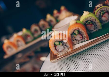 Grande set di panini al sushi caldo EBI sake Unagi Spring. Assortimento di piatti Philadelphia a base di pesce crudo giapponese in un piatto di lusso e tradizionali Foto Stock