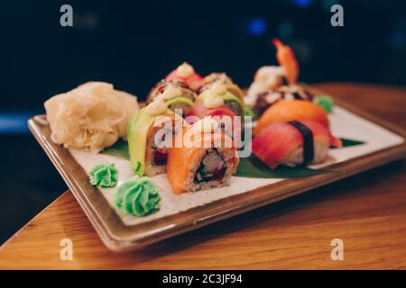 Grande set di panini al sushi caldo EBI sake Unagi Spring. Assortimento di piatti Philadelphia a base di pesce crudo giapponese in un piatto di lusso e tradizionali Foto Stock