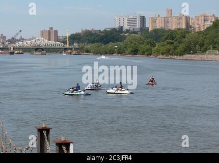 Un gruppo di persone su jet ski al molo di fronte al Peter Jay Sharp Boathouse sul fiume East o Harlem Foto Stock