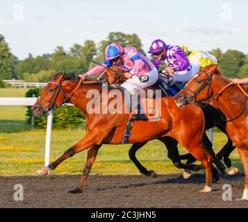 Unità di valutazione guidata dal fantino Tom Queally vince da Mordred e Kieran o’Neill (sulla ferrovia) nel casinò Unibet June Free Spin Festival handicap (Classe 4) presso l'ippodromo di Kempton Park. Foto Stock