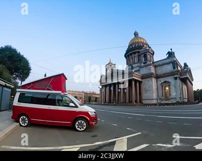 San Pietroburgo, Russia - 22 luglio 2019: Volkswagen moderno Volkswagen Multivan California Ocean (Transporter T6) di colore rosso e bianco. Parcheggiato per la notte nella strada di fronte alla cattedrale. Foto Stock