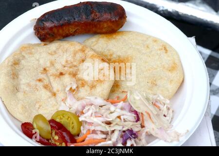 Tortillas di mais ripiene con ripieno di salato, servite con insalata di coleslaw piccante, peperoni caldi, salsa calda e chorizo Foto Stock