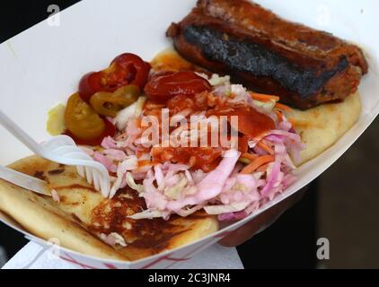 Tortillas di mais ripiene con ripieno di salato, servite con insalata di coleslaw piccante, peperoni caldi, salsa calda e chorizo Foto Stock