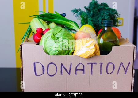 Scatola con frutta e verdura mele cavolo rafano olio zucchine, grits primo piano. Servizi di consegna di cibo durante la pandemia di coronavirus e sociale Foto Stock