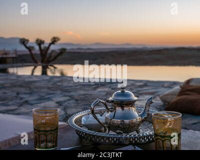 Primo piano di un tipico tè marocchino alla menta sul tavolo nel deserto di Agafay, Marrakech Foto Stock