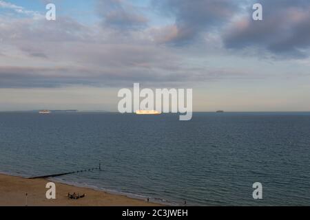 Bournemouth, Dorset UK. 20 giugno 2020. Le navi da crociera P&o Arcadia e Aurora ormeggiate a Poole Bay, Bournemouth, sulla costa meridionale, sono state unite da P&o Ventura e dalla Queen Victoria di Cunard come spazio insufficiente a Southampton; Non stanno navigando a causa della pandemia di Coronavirus che chiude il settore crocierario costringendo le aziende a mettere le loro navi. L'aurora si illumina nella luce della sera vista dalla spiaggia con le nuvole nel cielo. Credit: Carolyn Jenkins/Alamy Live News Foto Stock