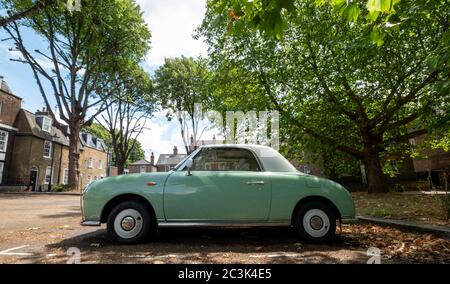 Auto verde vintage Nissan Figaro parcheggiata a Butts, Brentford, Londra ovest, Regno Unito. Foto Stock