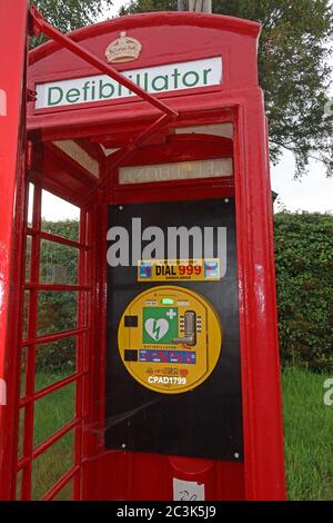 Defibrillatore in scatola telefonica britannica rossa, Marbury Village, Cheshire, Inghilterra, Regno Unito, AED, pronto soccorso cardiaco - salvavita Foto Stock