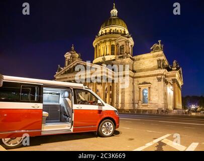 San Pietroburgo, Russia - 22 luglio 2019: Volkswagen moderno Volkswagen Multivan California Ocean (Transporter T6) di colore rosso e bianco. Parcheggiato per la notte nella strada di fronte alla cattedrale. Foto Stock