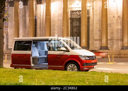 San Pietroburgo, Russia - 22 luglio 2019: Volkswagen moderno Volkswagen Multivan California Ocean (Transporter T6) di colore rosso e bianco. Parcheggiato per la notte nella strada di fronte alla cattedrale. Foto Stock