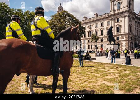 Londra / UK - 06/20/2020: Funzionari della polizia metropolitana sui cavalli che proteggono la statua di Sir Winston Churchill da essere vandalizzata da Black Lives Matters Foto Stock