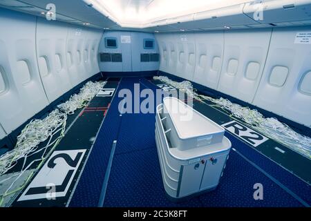 Vista interna di un passeggero convertito in aereo da trasporto con Rimosso sedili per volare maschere chirurgiche e abiti dalla Cina Combattere la pandemia di COVID Foto Stock