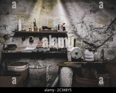 Interno di una vecchia fabbrica con pareti grugnose e industriale strumenti Foto Stock