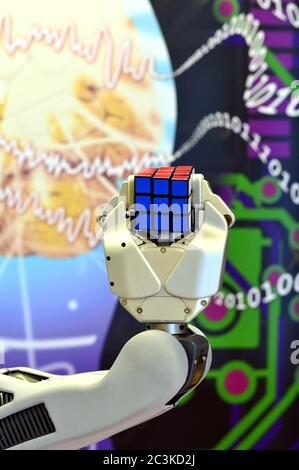 Londonderry, Regno Unito, febbraio 2017. Una mano di robot che tiene un cubo di Rubik con uno sfondo di cervello e numeri digitali. Foto Stock